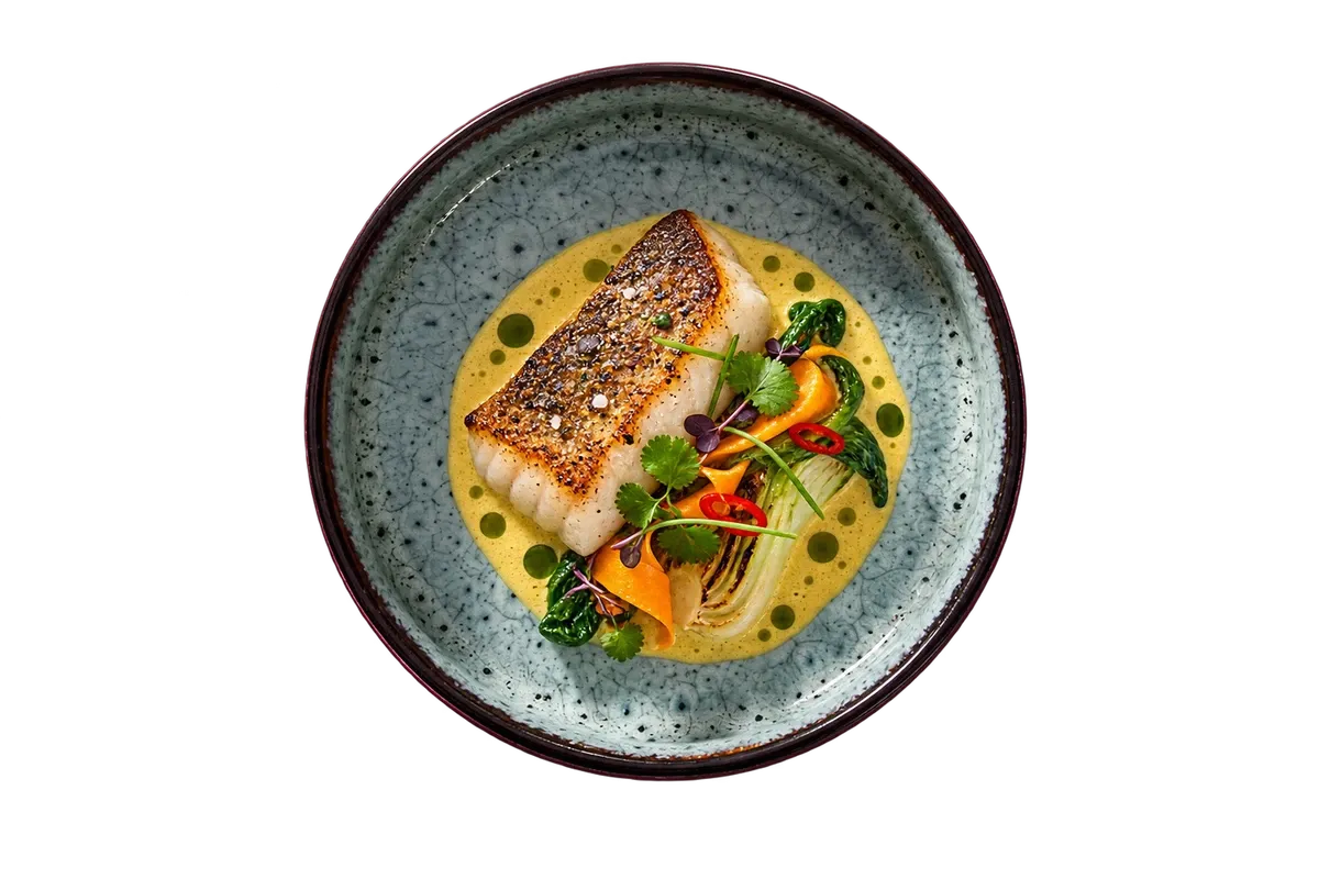 Coco Blue dinnerware serving pan-seared coastal fish with a small coconut-curry emulsion.